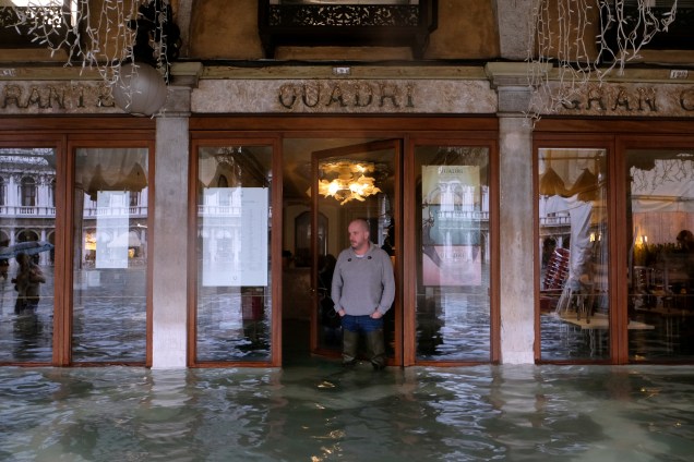 Um homem do lado de fora de um estabelecimento na Praça de São Marcos, em Veneza, que também foi atingida pelas tempestades — 24/11/2019
