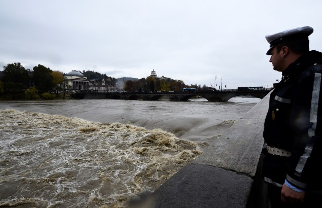 A man watches as Italy's longest river, river Po, has reached a critical level as torrential rain sweeps Italy flooding parts of Turin's city centre, in Turin, Italy — 24/11/2019