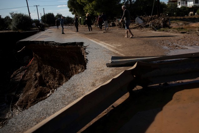 Habitantes atravessam ponte parcialmente desmoronada após inundações na cidade de Kineta, Grécia - 25/11/2019