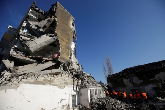 Pessoal de emergência trabalha perto de um prédio danificado em Thumane, Albânia — 26/11/2019