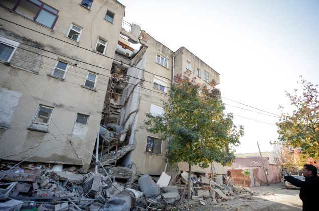 Um homem tira fotos de um prédio danificado em Durres, Albânia, após o terremoto — 26/11/2019
