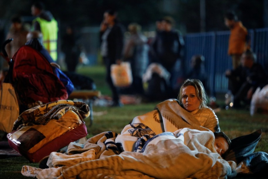 Uma mulher descansa ao lado de uma criança em um campo improvisado para condenados em Durres, Albânia — 26/11/2019