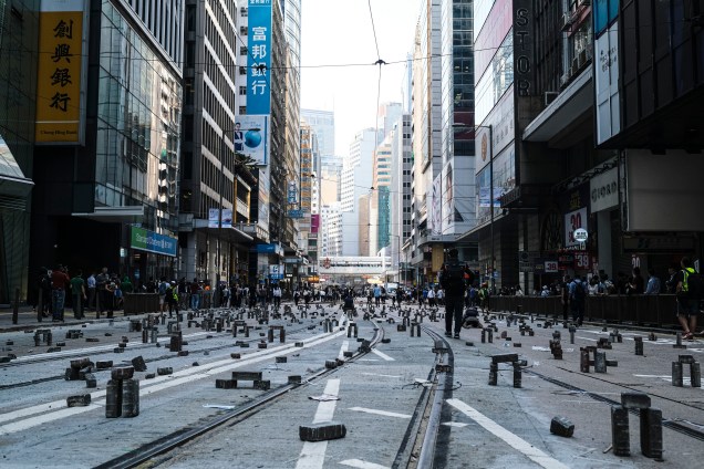 Manifestantes montam tijolos para bloquear o tráfego durante um protesto no distrito central de Hong Kong.