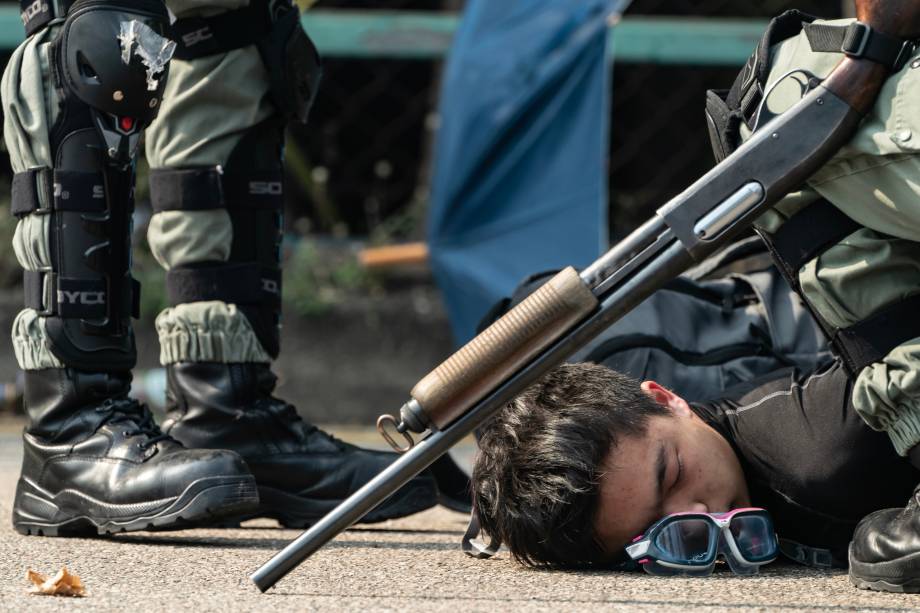 Um manifestante é detido pela polícia enquanto tenta escapar da Universidade Politécnica de Hong Kong