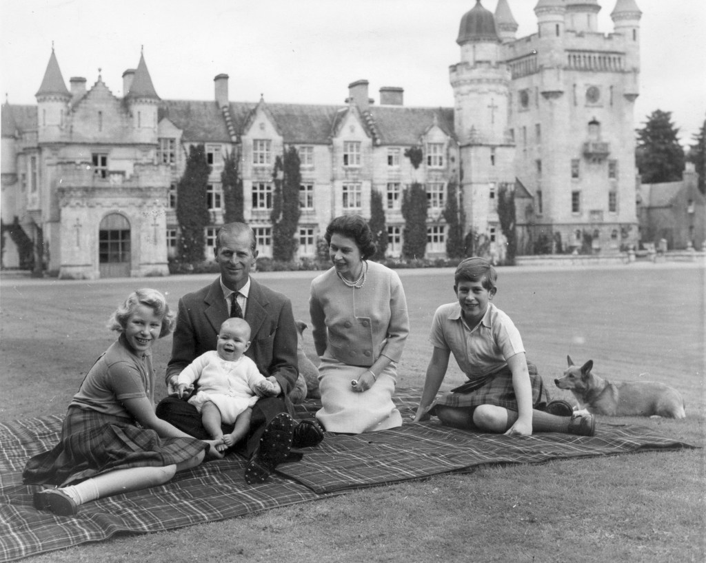 9th September 1960: Queen Elizabeth II and Prince Philip, Duke of Edinburgh with their children, Prince Andrew (centre), Princess Anne (left) and Charles, Prince of Wales sitting on a picnic rug outside Balmoral Castle in Scotland. Queen Victoria's husband, Prince Albert, purchased Balmoral Castle in 1846, and the small castle which stood in the 7,000 hectare wooded estate was redeveloped in the 1850s.The granite building was designed by Aberdeen architect William Smith with suggestions from Albert himself, who decided the interior decoration should represent a Highland shooting box with tartan or thistle chintzes, and walls decorated with trophies and weapons. Queen Victoria often visited the Highlands with her family, especially after Albertfs death in 1861, and Balmoral is still a popular retreat for the present royal family. (Photo by Keystone/Getty Images)