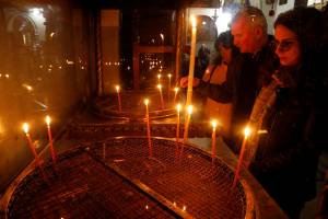 Visitors light candles in the Church of the Nativity in Bethlehem in the Israeli-occupied West Bank