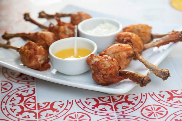 As famosas asinhas invertidas: oito tulipas de frango recheadas com purê de macaxeira e bacon, acompanhadas de maionese de alho e geleia de laranja As famosas asinhas invertidas: oito tulipas de frango recheadas com purê de macaxeira e bacon, acompanhadas de maionese de alho e geleia de laranja