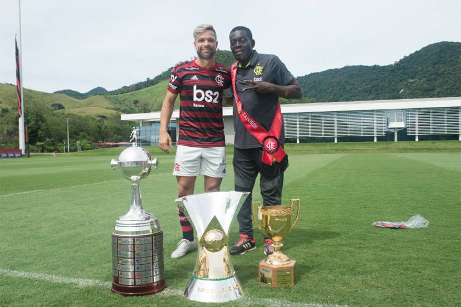 Diego e o massagista Adenir Silva com as taças da temporada, no Ninho do Urubu