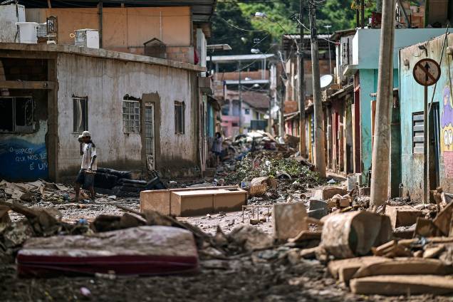 Um morador local caminha entre escombros após o transbordamento do córrego Da Prata devido a chuvas torrenciais, em Raposos, região metropolitana de Belo Horizonte, em 28 de janeiro