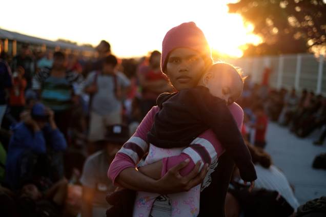 Uma migrante, parte da caravana que viaja para os EUA, segura uma criança enquanto outras se reúnem perto da fronteira entre a Guatemala e o México, em Tecun Uman - 20/01/2020