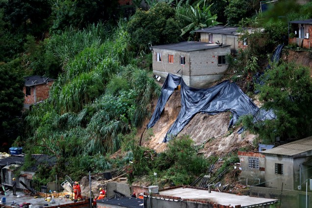 Equipes de resgate pesquisam o local de um deslizamento de terra, após fortes chuvas no bairro Vila Ideal em Belo Horizonte, em 24 de janeiro de 2020