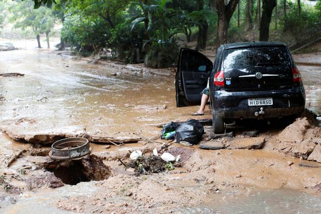 Carro e rua danificados são retratados após fortes inundações causadas por chuvas em Belo Horizonte, 29 de janeiro