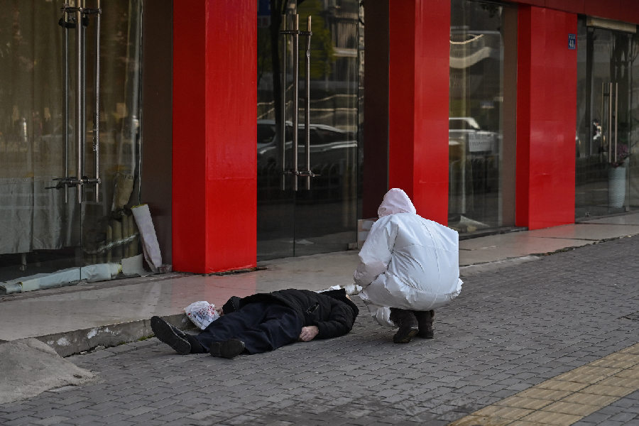 Homem cai na rua na cidade de Wuhan, epicentro do surto de coronavírus