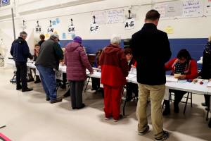 Voters check-in before casting their ballots in the New Hampshire U.S. presidential primary election at the Webster School, in Manchester