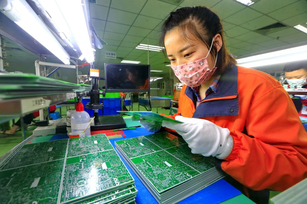 Trabalhadora chinesa utiliza máscara durante o trabalho em uma fábrica na província de Sichuan /
