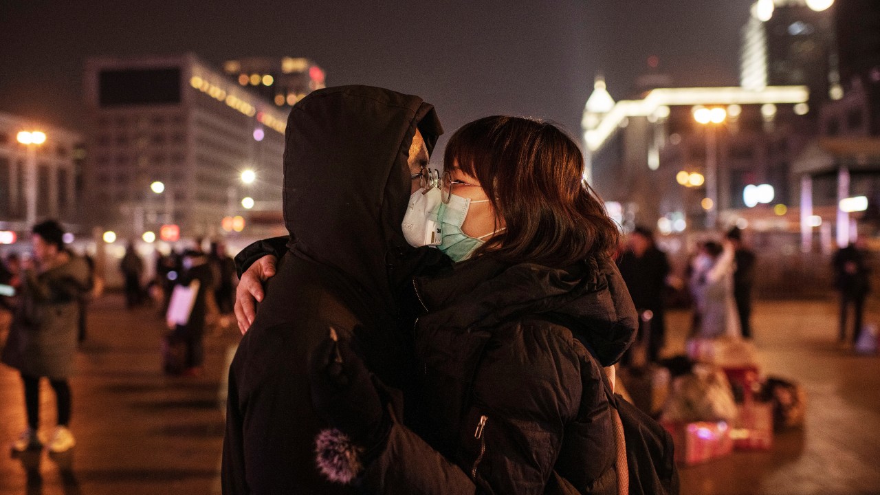 Por coronavírus, casal chinês se beija usando máscaras de proteção antes de pegar o trem em estação de Pequim, antes do Festival de Primavera (22/01/2020)