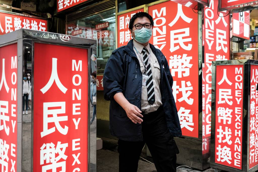 Segurança trabalha com máscara em área de caixas-eletrônicos em Hong Kong: endereço de novos pacientes divulgados a cada dia pelo governo - 13/03/2020