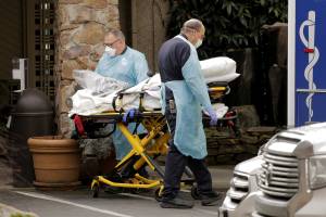 Medics transport a person on a stretcher into an ambulance at the Life Care Center of Kirkland, a long-term care facility linked to several confirmed coronavirus cases, in Kirkland