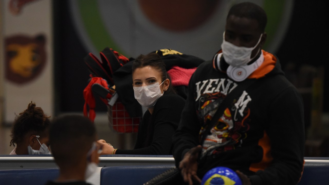 Passageiros usam máscaras para tentar se proteger do coronavírus no Aeroporto Internacional Galeão, no Rio de Janeiro