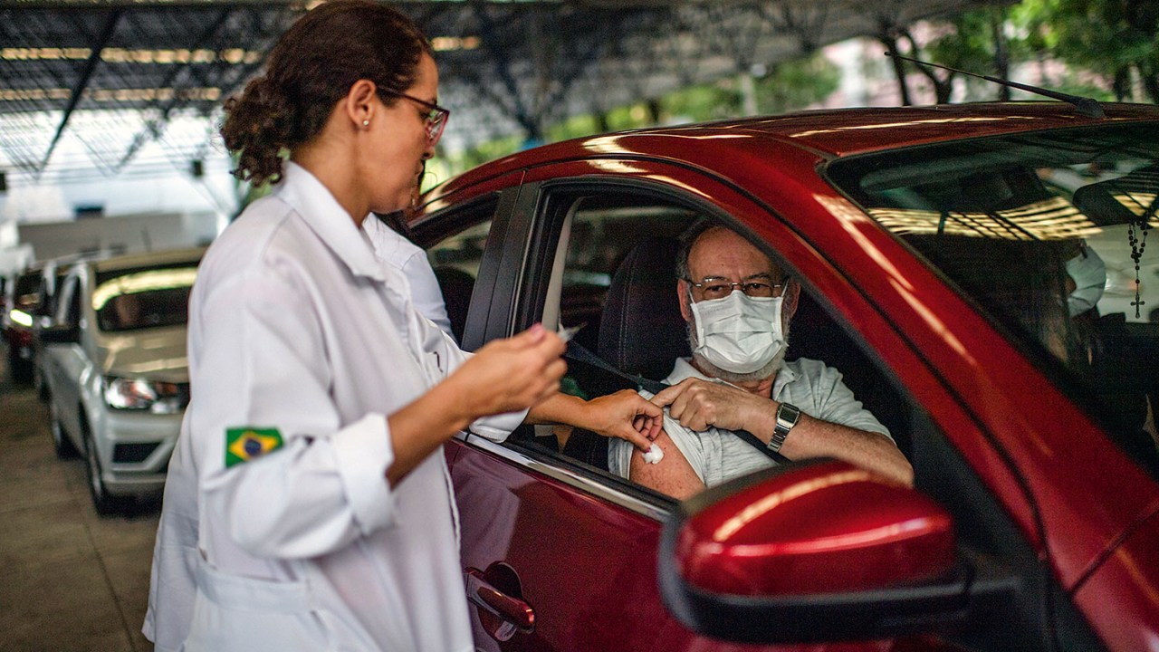 SAÍDA DE EMERGÊNCIA - Idoso toma vacina contra a gripe no Rio, na terça-feira 24, sem deixar o carro: grupo de risco