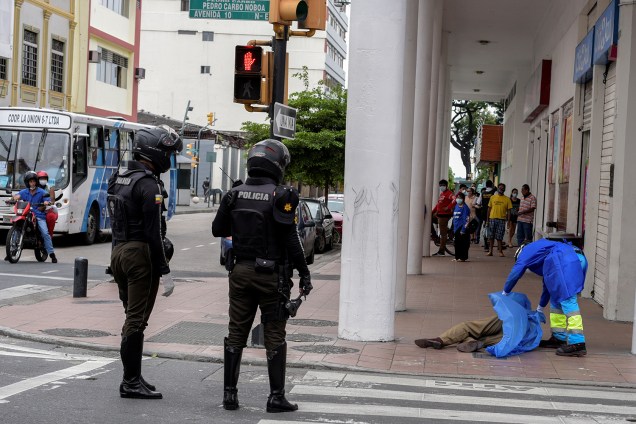 Um paramédico cobre o corpo de um homem que morreu após desmaiar na calçada, durante o surto do coronavírus, em Guayaquil, no Equador