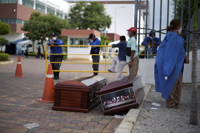 Pessoas esperam ao lado de caixões do lado de fora do Hospital Geral Guasmo Sur, em Guayaquil, no Equador