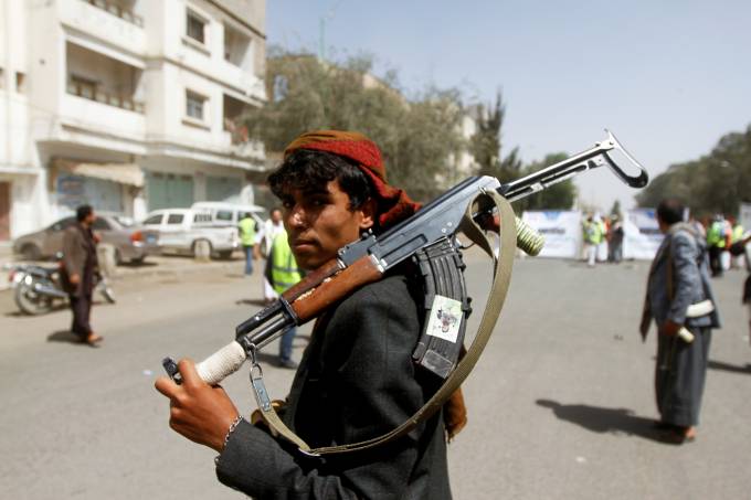 FILE PHOTO: A Houthi supporter looks on as he carries a weapon during a gathering in Sanaa