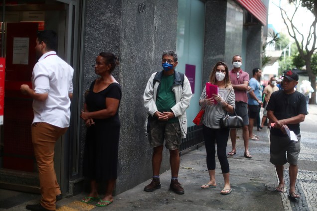 Pessoas esperam na fila para entrar no banco durante o surto do coronavírus, no bairro de Copacabana, no Rio de Janeiro