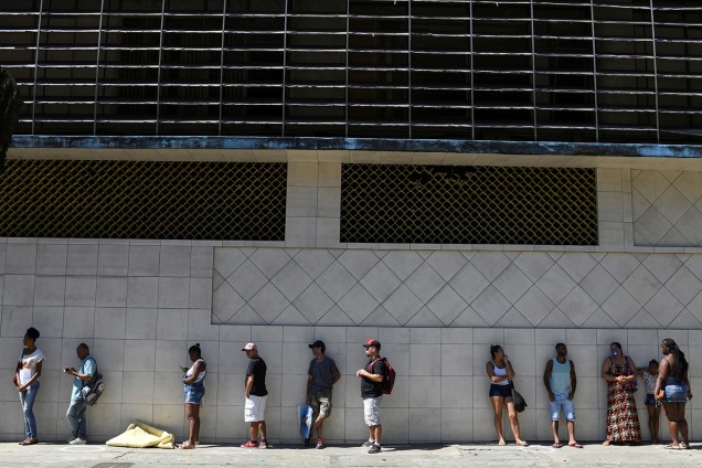 Pessoas esperam na fila em frente ao banco da Caixa para tentar receber ajuda emergencial do governo federal em meio ao surto do coronavírus, no Rio de Janeiro