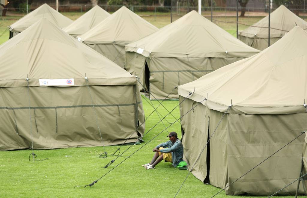 A homeless man looks on at a makeshift shelter A homeless man looks on at a makeshift shelter