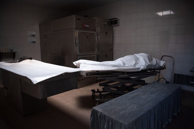 Respeito: O corpo de um homem de 86 anos é coberto com um lençol na câmara funerária do cemitério Chateauneuf-les-Martigues, no sul da França