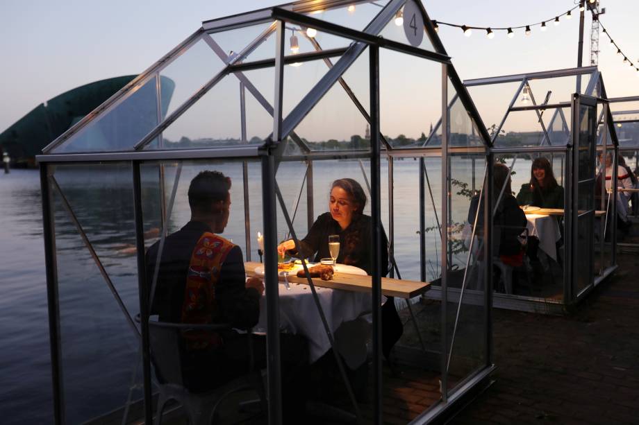Restaurante em Amsterdã, na Holanda, implementa o uso de estufas individuais para manter a distância segura entre os clientes e evitar a propagação do novo coronavírus.
