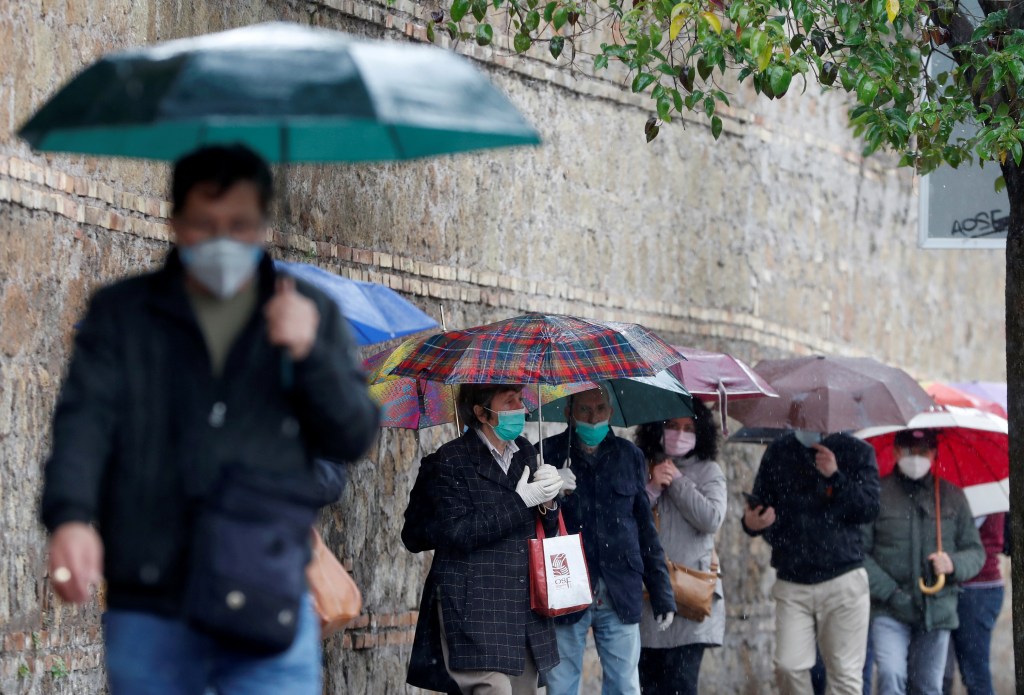 FILE PHOTO: People queue to receive free protective masks that have been bought by evangelicals in China and are distributed by Members of the Evangelical Christian Church, as the spread of the coronavirus disease (COVID-19) continues, in Rome, - 22/04/2020