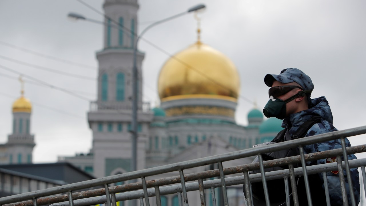Policial faz guarda diante da Grande Mesquita de Moscou, fechada durante festival muçulmano que marca o fim do Ramadã devido à Covid-19 - 24/05/2020