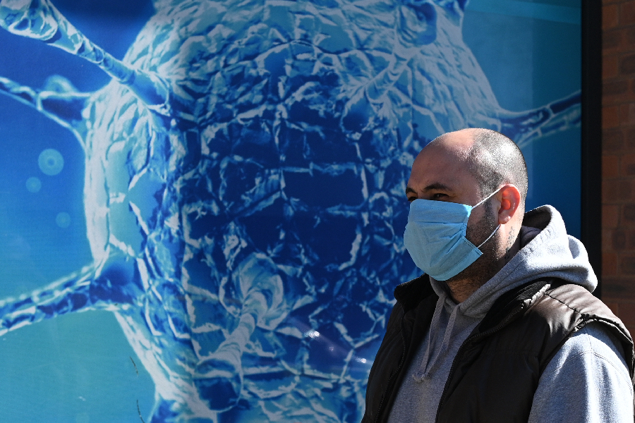 Homem anda de máscara em Oldham, Inglaterra, em meio à pandemia de coronavírus