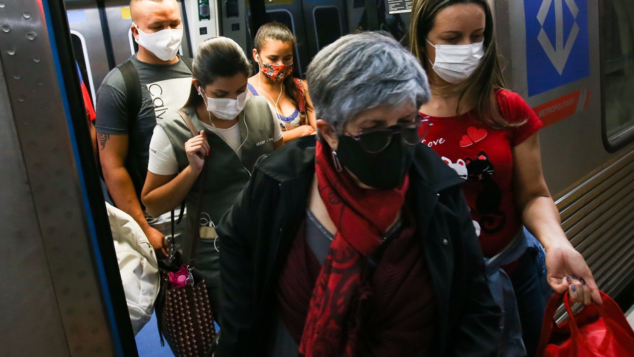 Passageiros usando máscaras faciais deixam um vagão do metrô, em São Paulo