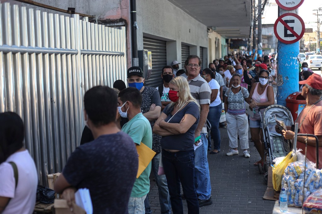 Clientes esperam na fila do lado de fora de uma agência bancária da Caixa Econômica Federal, em São Gonçalo, no Rio de Janeiro