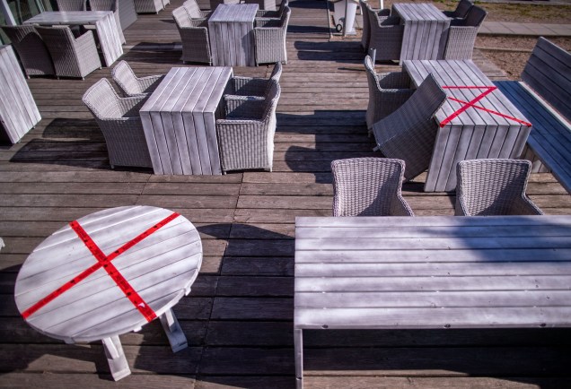 Um restaurante ao ar livre no lago Schwerin, na Alemanha, usou fita vermelha para isolar alguns assentos e garantir que seja mantida a distância mínima entre os clientes.