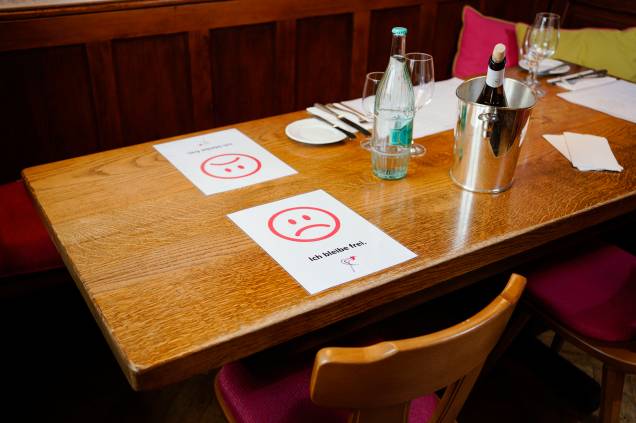 Folhetos sinalizam onde clientes podem sentar e onde não podem de forma a manter  uma distância segura para proteção contra o novo coronavírus no restaurante do hotel Deidesheimer Hof, em Deidesheim, na Alemanha.