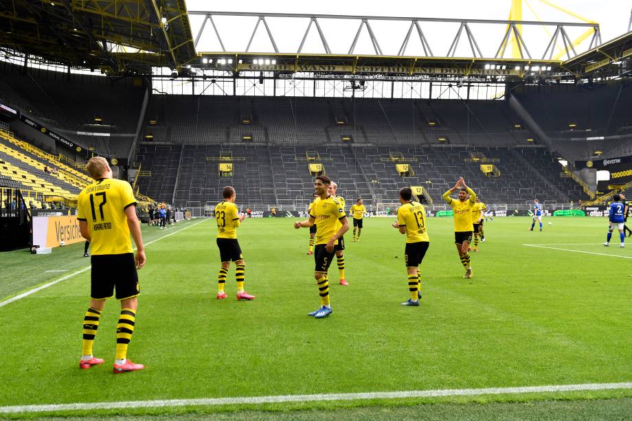 O noruguês Erling Haaland comemora (à distância) com seus companheiros de equipe do Borussia Dortmund