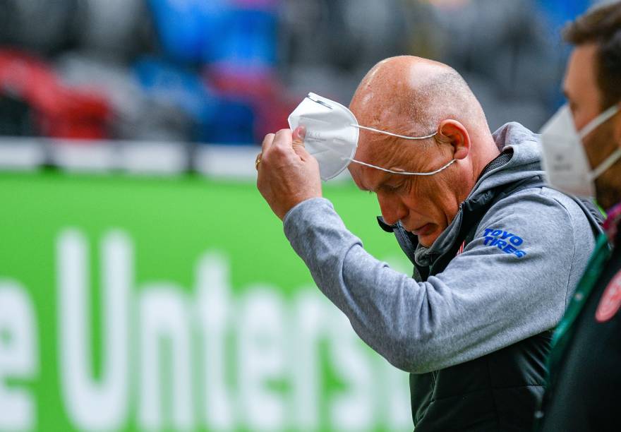 O técnico Uwe Rösler, do Fortuna Düsseldorf, tira a máscara para conceder entrevista à beira do gramado