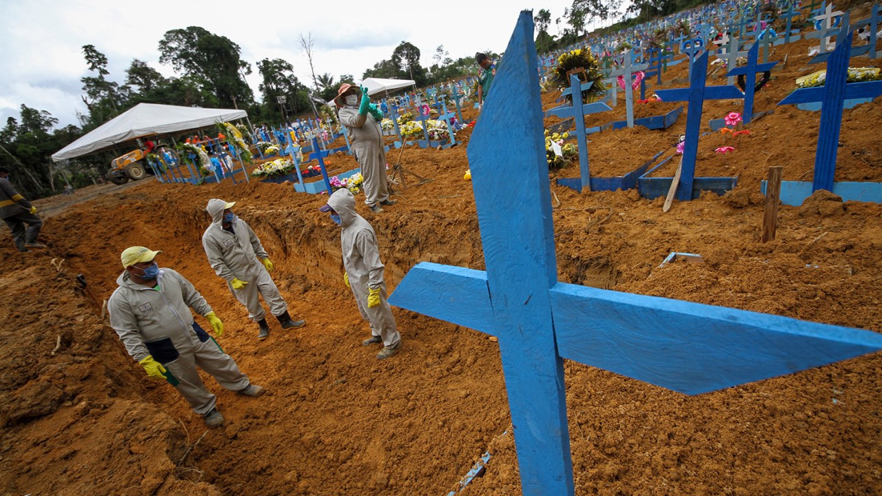 Coveiros trabalham em uma vala comum no cemitério Nossa Senhora Aparecida, em Manaus