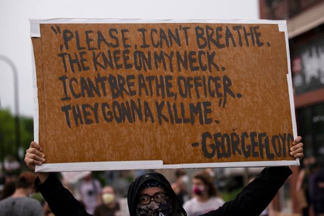 Um manifestante segura um cartaz com os dizeres de George Floyd durante a abordagem policial "Por favor, eu não consigo respirar. O joelho no meu pescoço. Eu não consigo respirar, policial. Eles vão me matar"