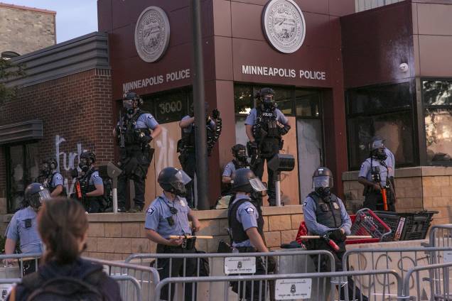 A polícia vigia manifestantes durante o segundo dia de protestos pela morte de George Floyd, em Minneapolis.