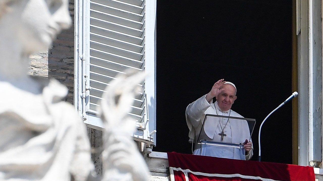 O Papa Francisco acena para a multidão da janela do palácio apostólico com vista para a praça de São Pedro durante a oração do Angelus de domingo, em 7 de junho de 2020, no Vaticano. (Foto de Andreas SOLARO / AFP)
