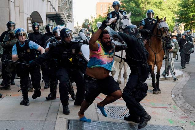 A polícia de choque persegue um homem enquanto apressam os manifestantes para liberar o Lafayette Park e a área ao redor da Casa Branca - 01/06/2020 A polícia de choque persegue um homem enquanto apressam os manifestantes para liberar o Lafayette Park e a área ao redor da Casa Branca - 01/06/2020