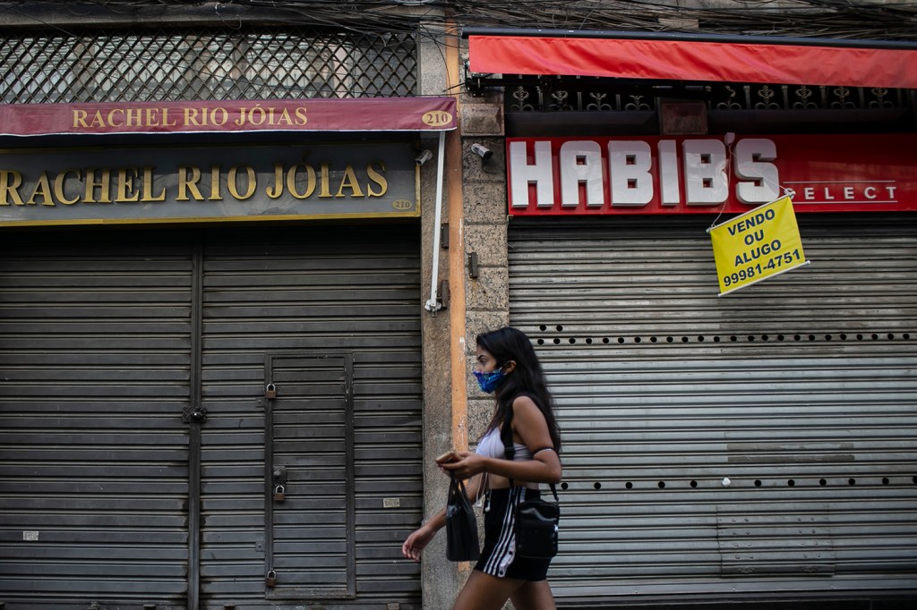 Uma mulher de máscara caminha no centro comercial de Saara na primeira segunda-feira de quarentena relaxada na cidade do Rio de Janeiro