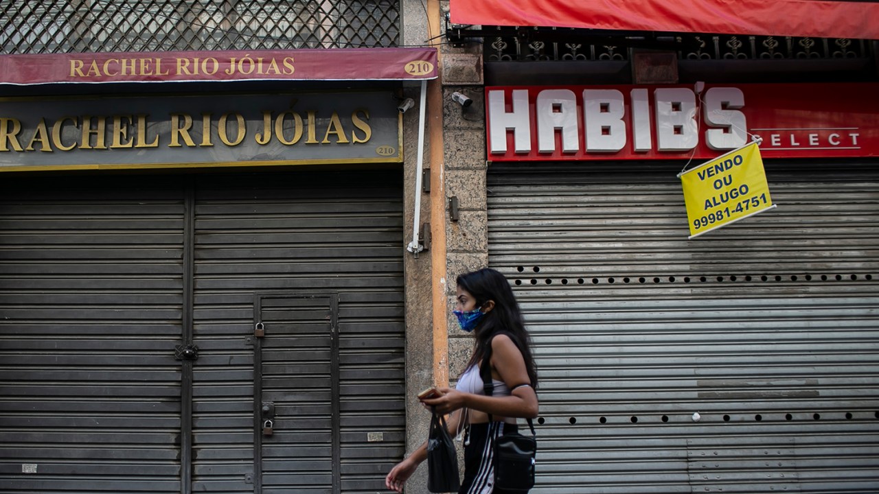 Uma mulher de máscara caminha no centro comercial de Saara na primeira segunda-feira de quarentena relaxada na cidade do Rio de Janeiro