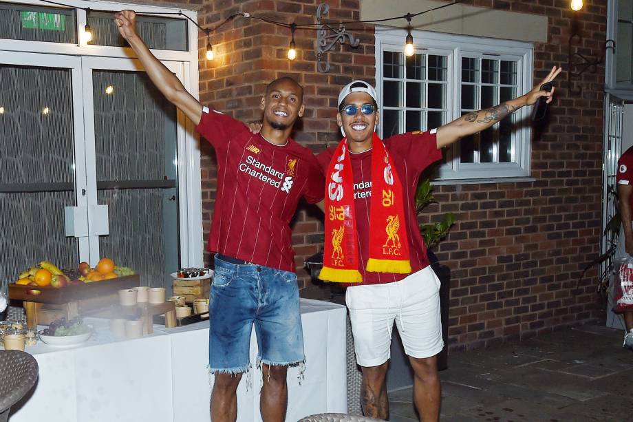 Fabinho e Roberto Firmino comemorando o título da Premier League com companheiros de equipe