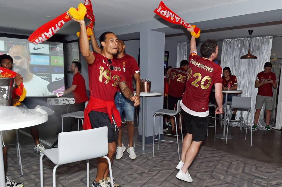 Virgil van Dijk e Andy Robertson comemorando o título da Premier League com companheiros de equipe